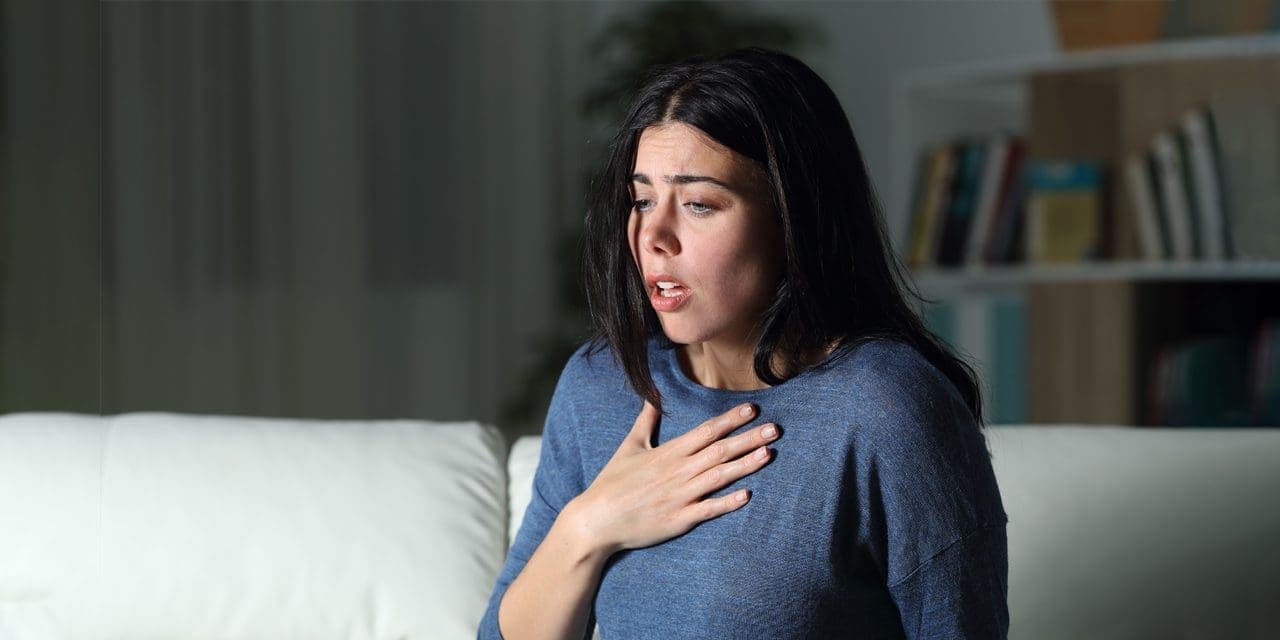 woman having hard time of breathing, palm on her chest